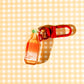 Back view -- Decorative charm shaped like a bottle of fish sauce with text "i'm fuckin' ngon" on orange label.