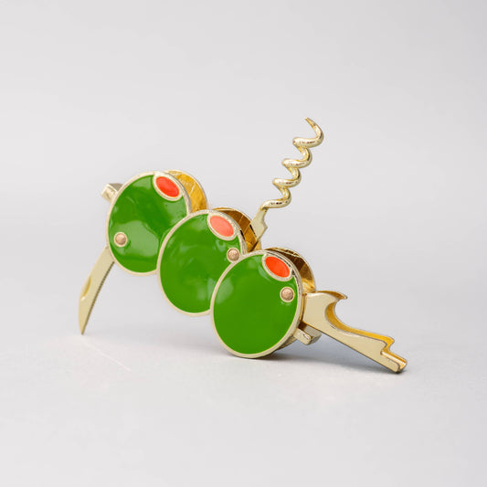 Gold corkscrew with green olive and red pimento on a light gray background
