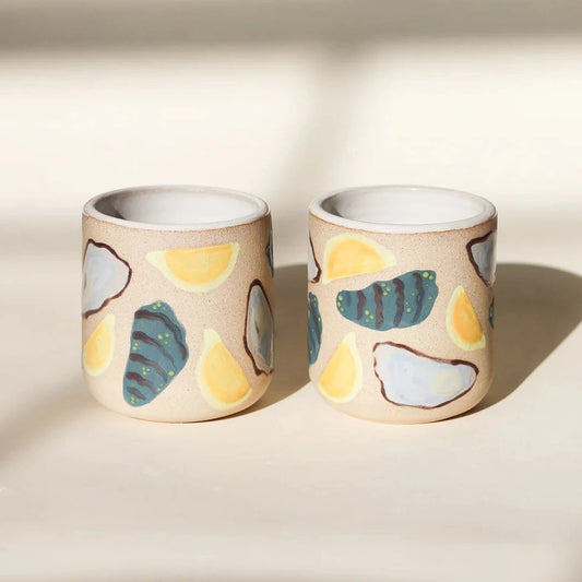 Ceramic tumblers designed with lemon wedges and half shell oysters