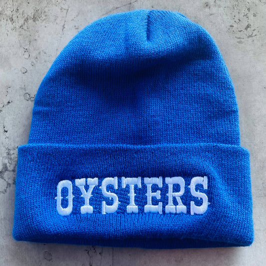 blue knit beanie with white embroidered text that reads "oysters" 