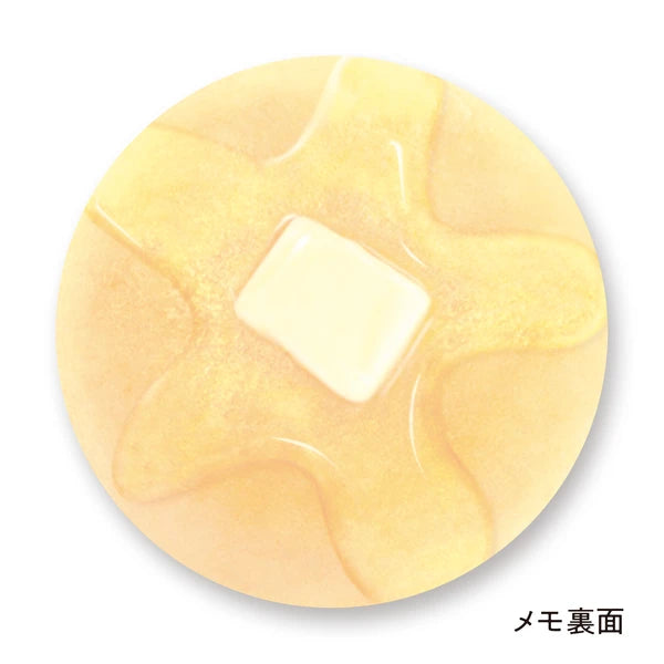 Memo pad that looks like a pancake with a melted pad of butter and syrup on it. Back side has a lighter print on it but is the same design as the front.