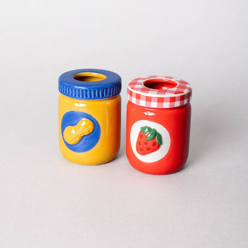 Two colorful jars with blue and red lids on a white background