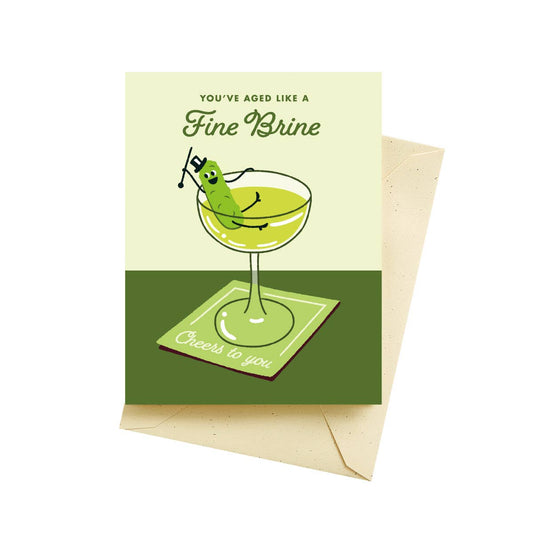 Greeting card with a pickle in a martini glass and text 'You've aged like a fine brine. Cheers to you.'