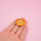 Pizza magnet on a hand to show the size detail.