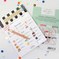 pretend play notepad with 'Cozy Cafe' design on a white background with colorful confetti.