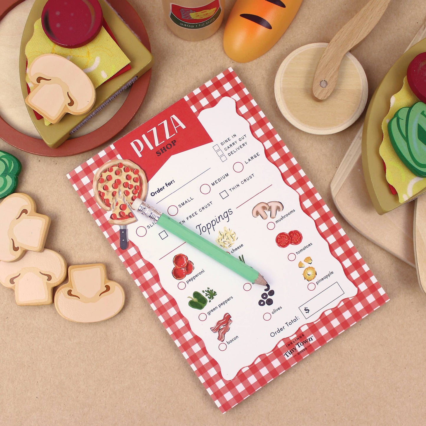 Pizza shop order form with wooden pizza toppings on a beige surface