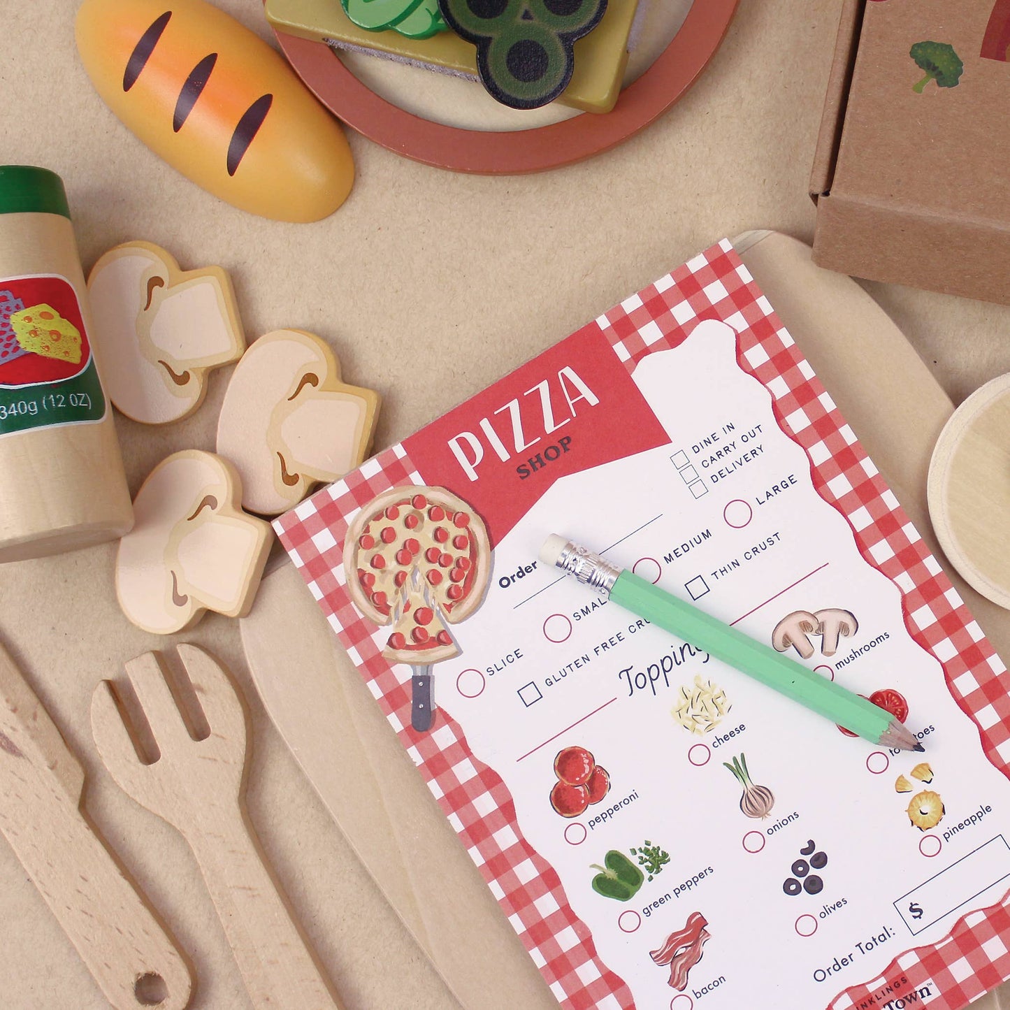 Pizza ordering play activity sheet with toy food items on a checkered tablecloth