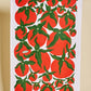 Tea towel with red tomato pattern on a white background