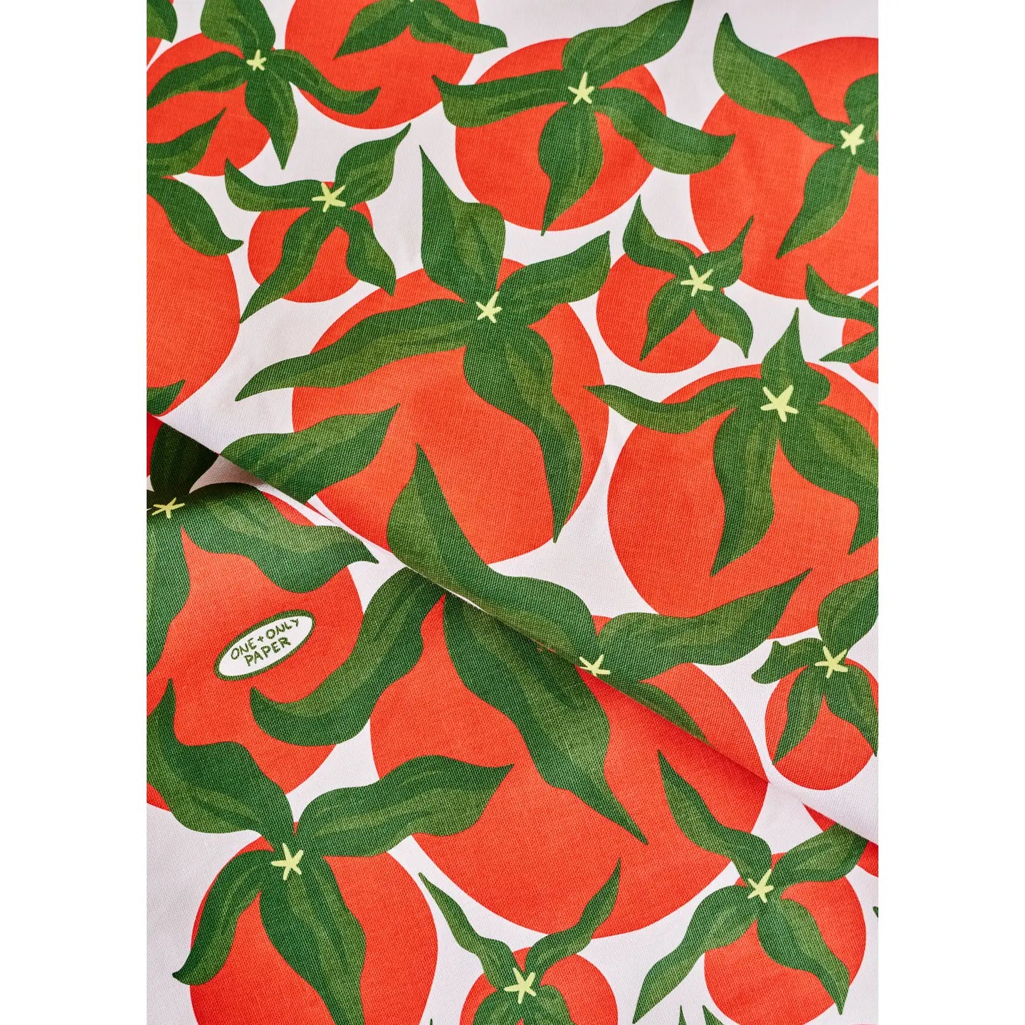 Patterned towel with red tomatoes and green leaves on a white background