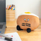 Baked potato plush toy sitting on a desk next to computer