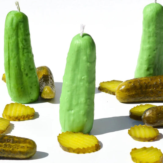 three pickle candles staged with real pickles.