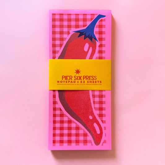 Notepad with red and blue design on a pink background, featuring 'Pier Six Press' branding.