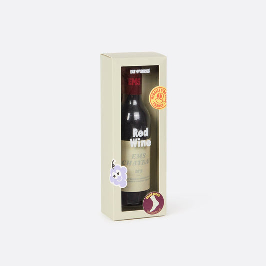 socks packaged to look like a red wine bottle in a decorative box on a white background