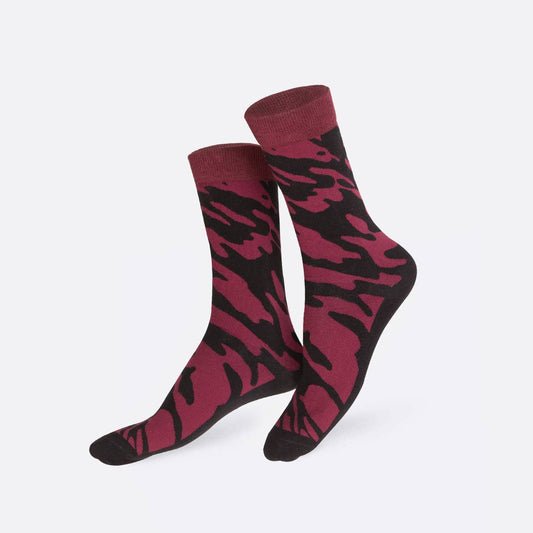 Pair of maroon and black camouflage patterned socks on a white background