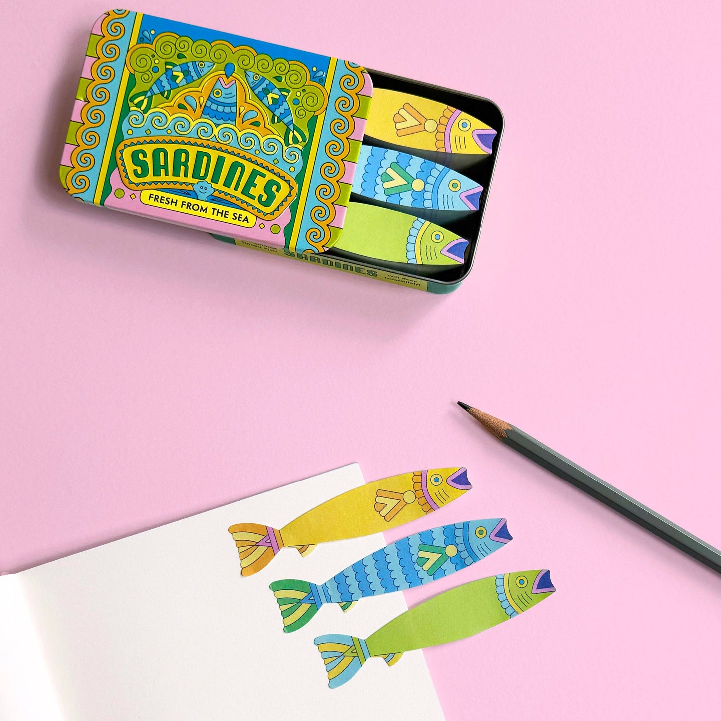 Colorful Sardine packaging with illustrations for fish shaped sticky notes on a pink background