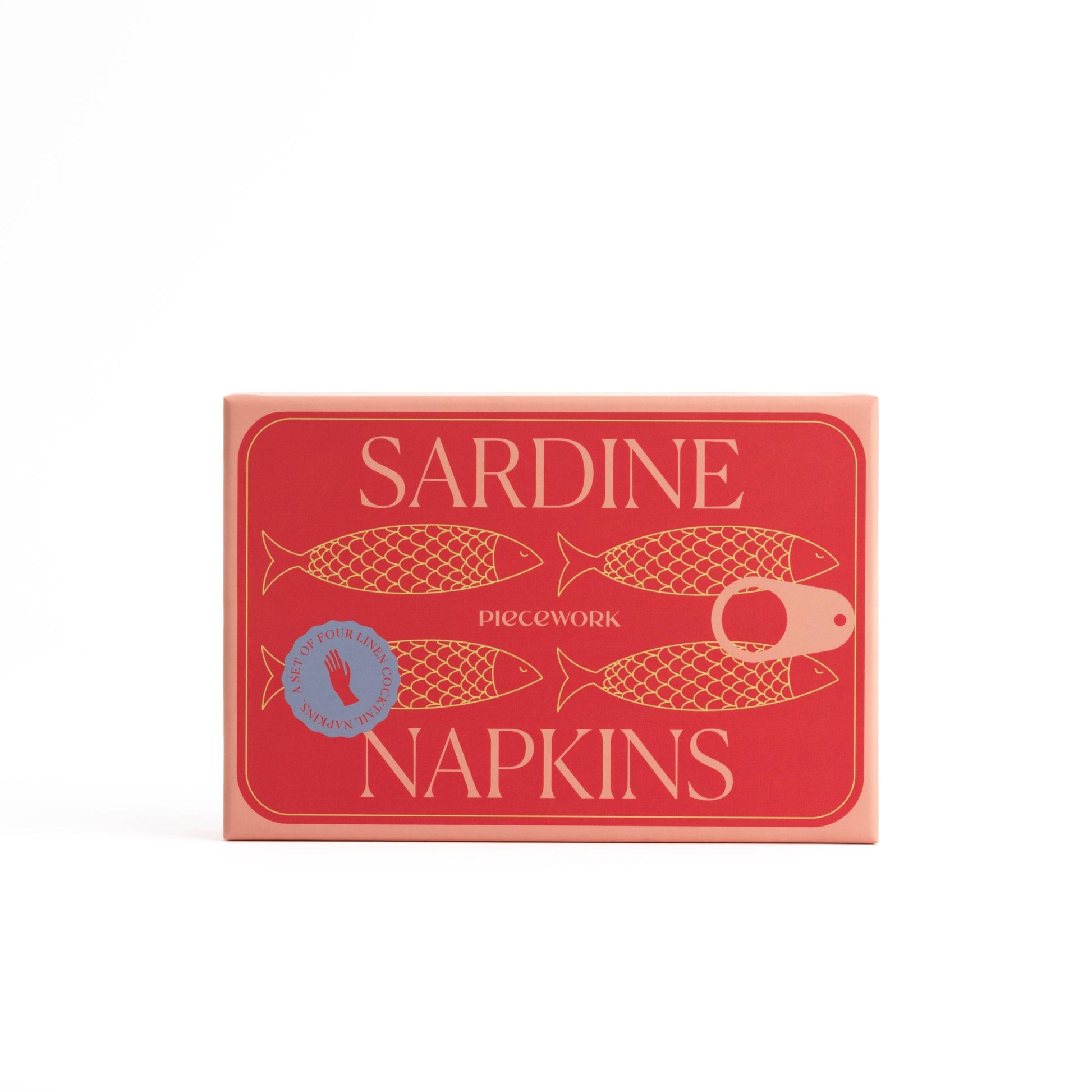 Red and salmon colored box with 4 sardines drawn on the front. The box says Piecework, Sardine Napkins, Set of 4 Linen Cocktail Nap