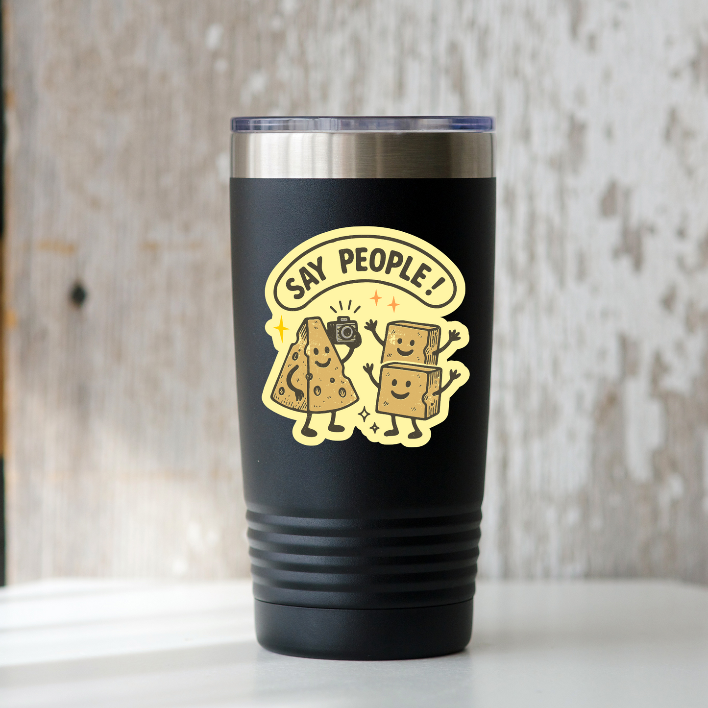 Black tumbler with yellow graphic and text 'Say People!' on a wooden surface.