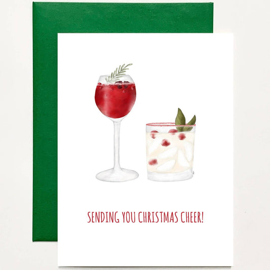 Holiday card that reads: Sending you Christmas Cheer! Card has an image of mulled wine with rosemary and a cocktail with laurel leaves and cranberries. Paired with a green envelope.