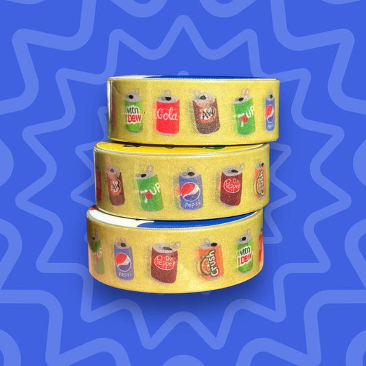 Three rolls of yellow washi tape with soda can designs on a blue wavy background
