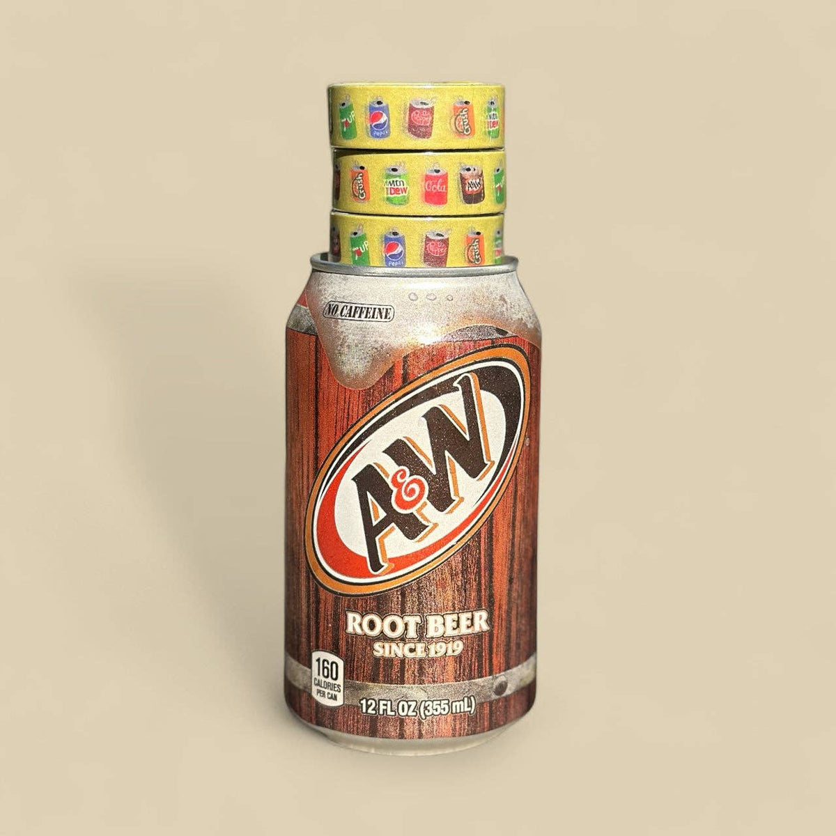 A&W Root Beer can on a beige background with 3 rolls of yellow soda design washi tape on top