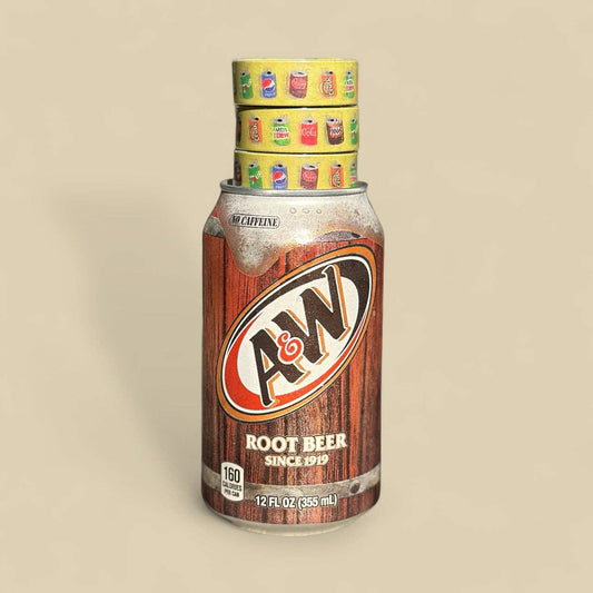 A&W Root Beer can on a beige background with 3 rolls of yellow soda design washi tape on top