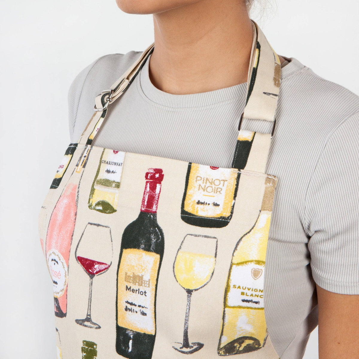 Person wearing a wine-themed apron with illustrations of wine bottles and glasses.