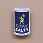Sticker with a design of a salt container and person holding an umbrella, with 'Stay Salty' text on a beige background.