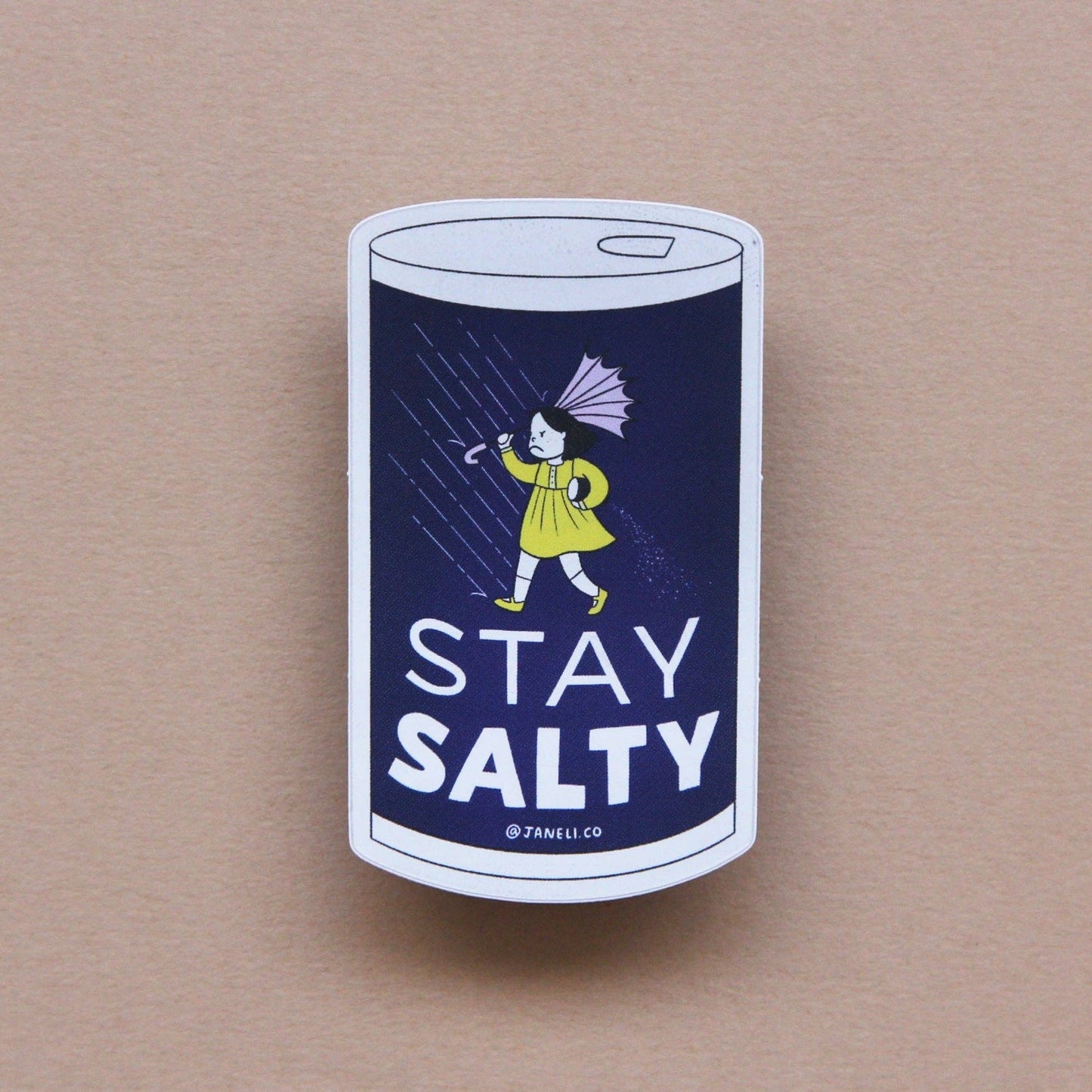 Sticker with a design of a salt container and person holding an umbrella, with 'Stay Salty' text on a beige background.