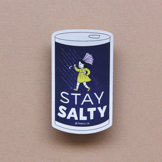 Sticker with a design of a salt container and person holding an umbrella, with 'Stay Salty' text on a beige background.