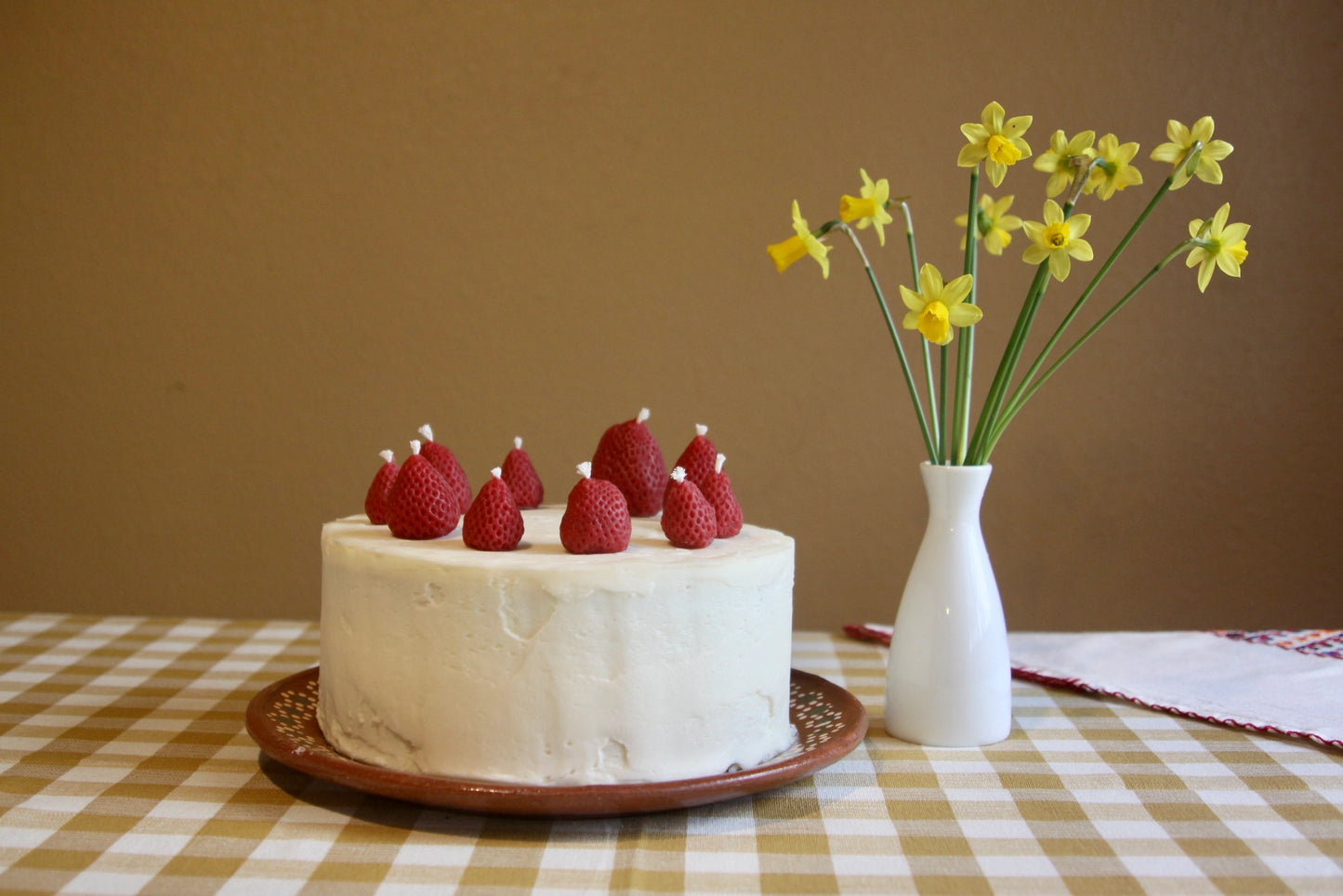 Strawberry candles on a cake with cotton wicks. Not lit.