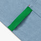 Blue apron with red straps. This apron is dedicated to strawberries with embroidery of strawberries in a basket and on a vine with little white flowers. Close up detail of a small green towel strap.