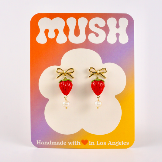 Earrings on a 'MUSH' branded card with a colorful gradient background