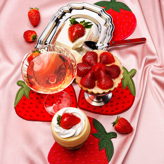 Dessert platter with strawberry-themed decor on a pink fabric background. Showcasing strawberry napkins
