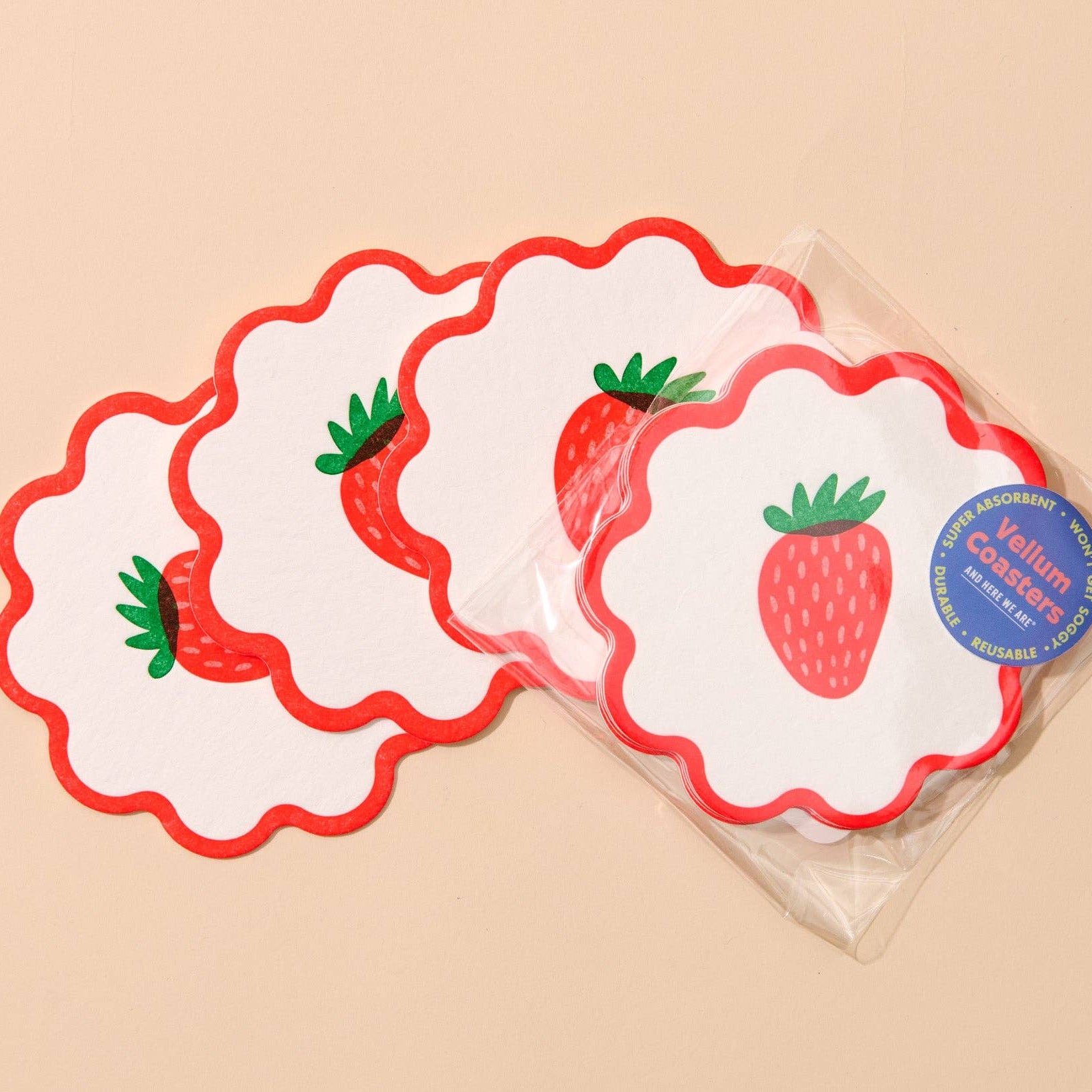Set of strawberry-themed coasters in a clear plastic packaging on a beige background