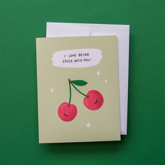 Greeting card with cherries and text on a green background