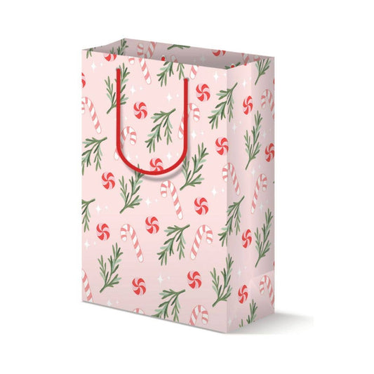 Holiday gift bag that is pink with candy canes and peppermint candy pattern. Rosemary or pine leaves are also scattered throughtout. Red rope handle.