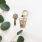 Photo of Boba Keychain with teal colored straw. Shown next to a house key for size.