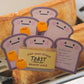 toast-shaped memo pad with cartoon faces on a piece of toast.