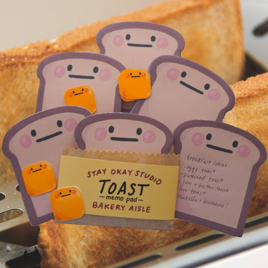 toast-shaped memo pad with cartoon faces on a piece of toast.