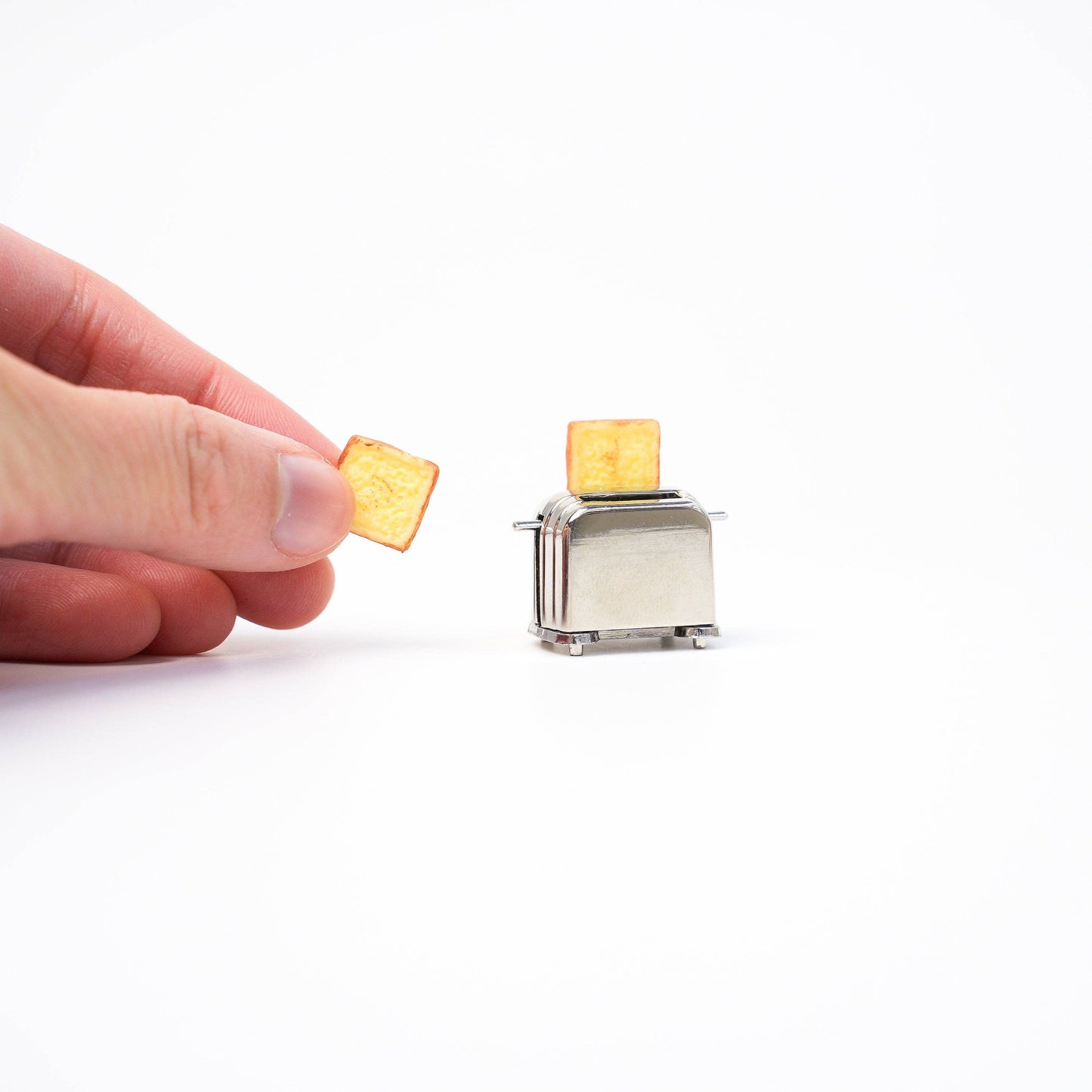 Hand putting toast inside the mini  toaster magnet