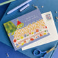 birthday card with light blue background and illustration of a turtle wearing a party hat and a large sheet cake decorated with flowers and text that says "happy birthday" and has lots of candles on top. Card reads "don't worry no one's counting" on the outside 
