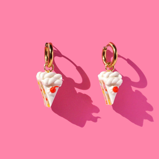 Whilte Cake earrings on a pink background
