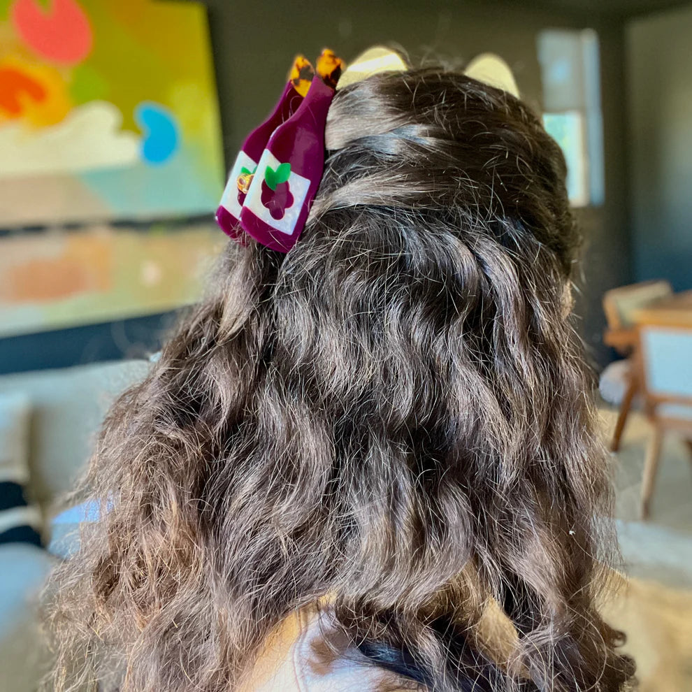 Red wine hair clip in a girl's hair.