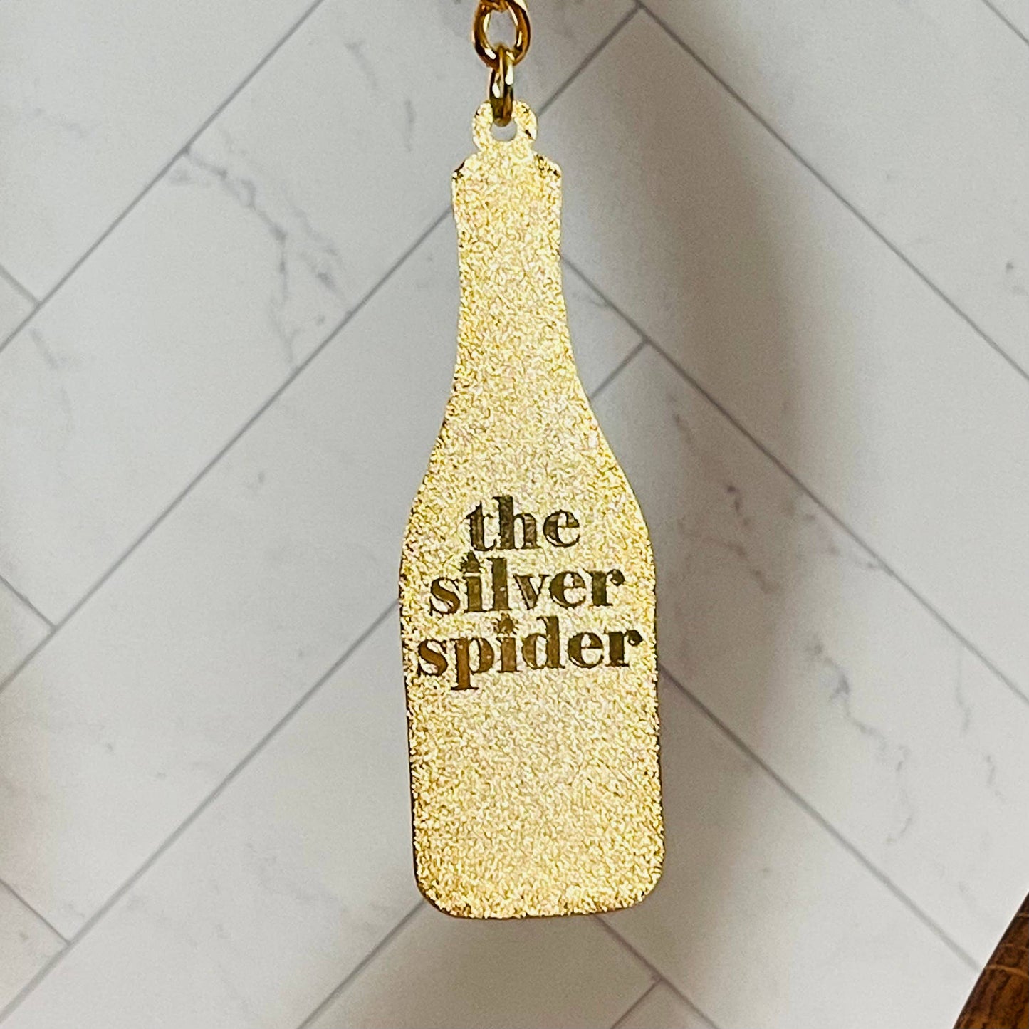 Back of keychain showing text: the silver spider