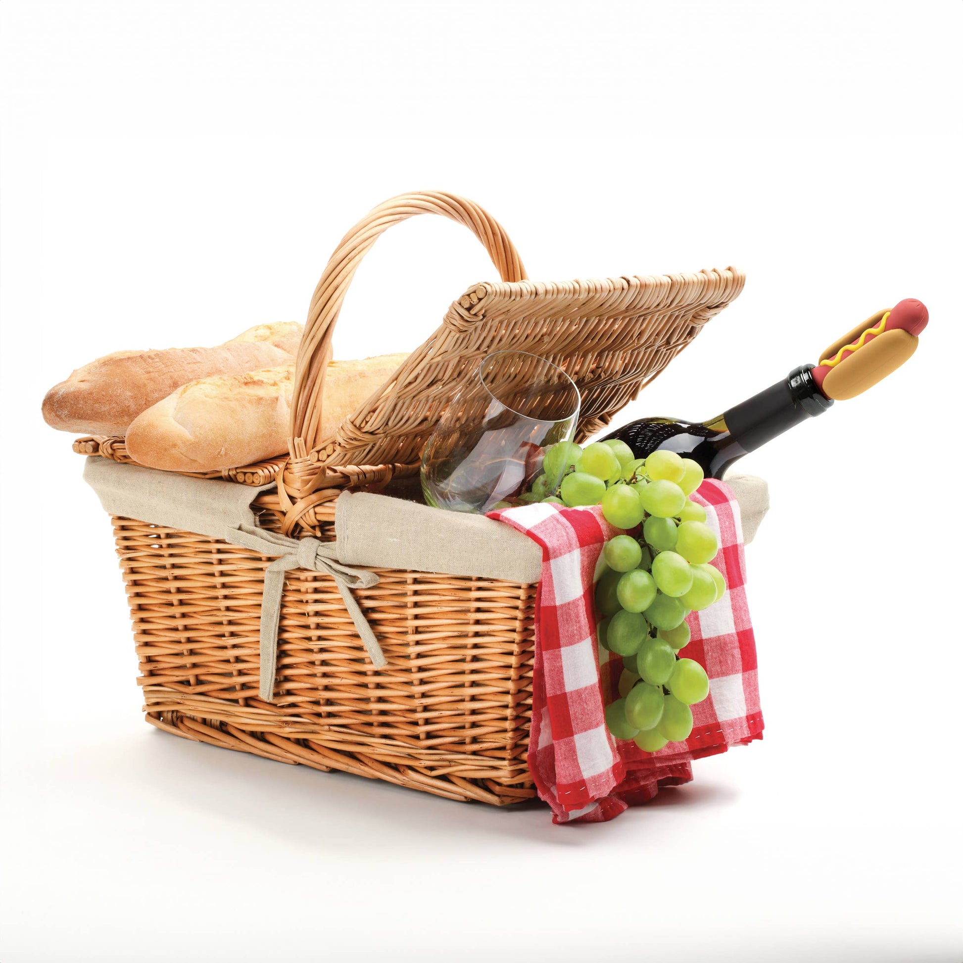 Picnic basket will things falling out of it including bread, a gingham red/white cloth, wine glass, grapes and a wine bottle with a wine wiener stuck inside.