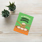 Graduation card with cartoon design on a wooden surface with plants