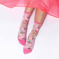 Pink, sheer, women's socks on model -- socks have cakes, ice cream, milkshakes and candy on them 