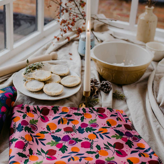 Pink botanical fruits tea towel on table setting 