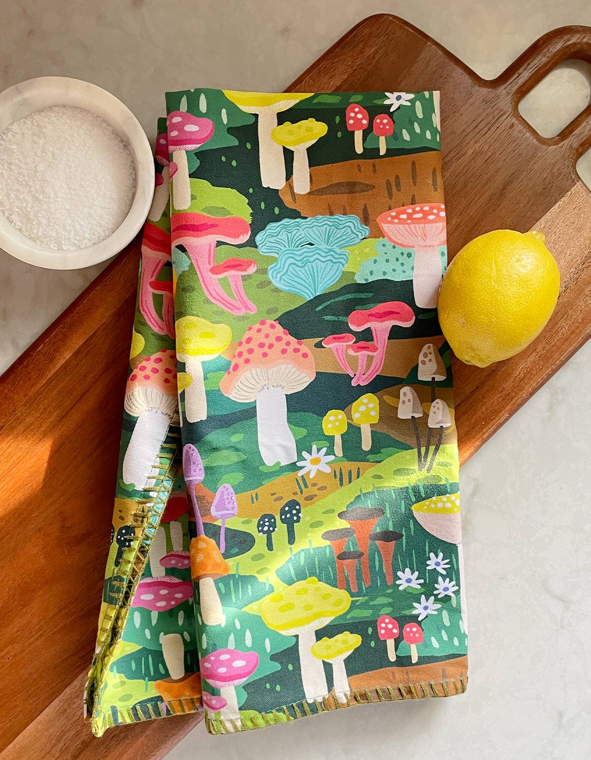 Colorful mushroom tea towel. Shown here on cutting board with a lemon and bowl of salt 