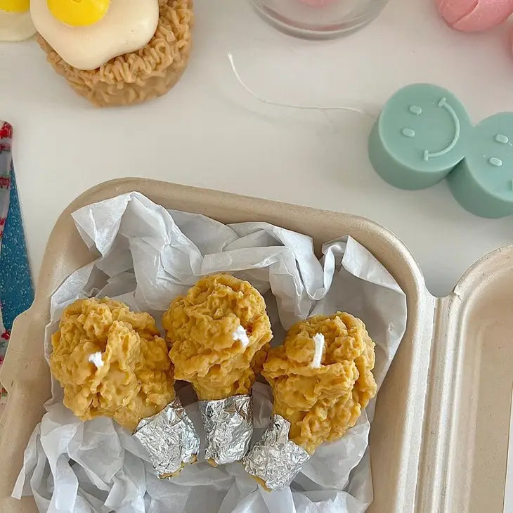 Set of three decorative candles that look like crispy fried chicken.